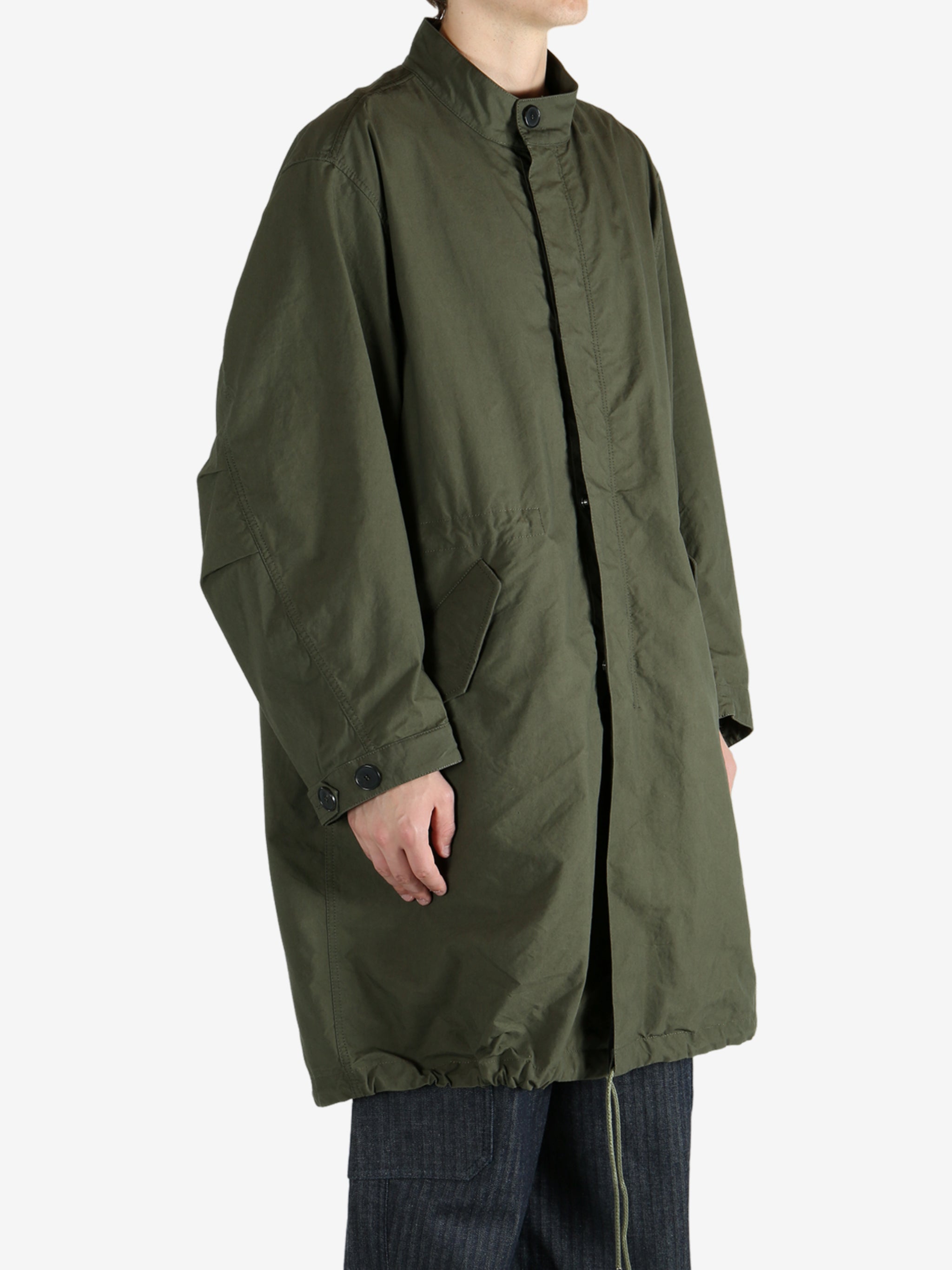 Green coat worn by a person, showing the coat fit
