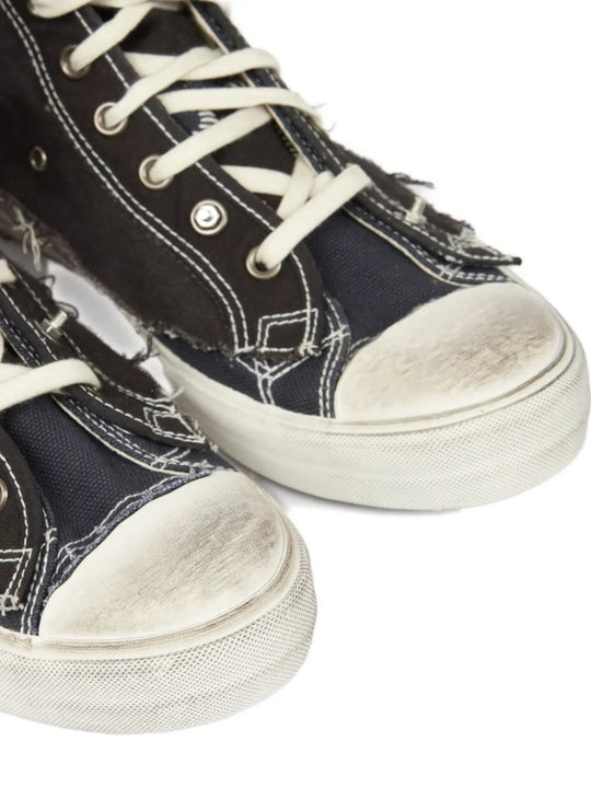 Close up of black sneakers, showing texture of the cotton and rubber and goat leather fabric