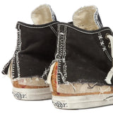 Close up of black sneakers, showing texture of the cotton and rubber and goat leather fabric