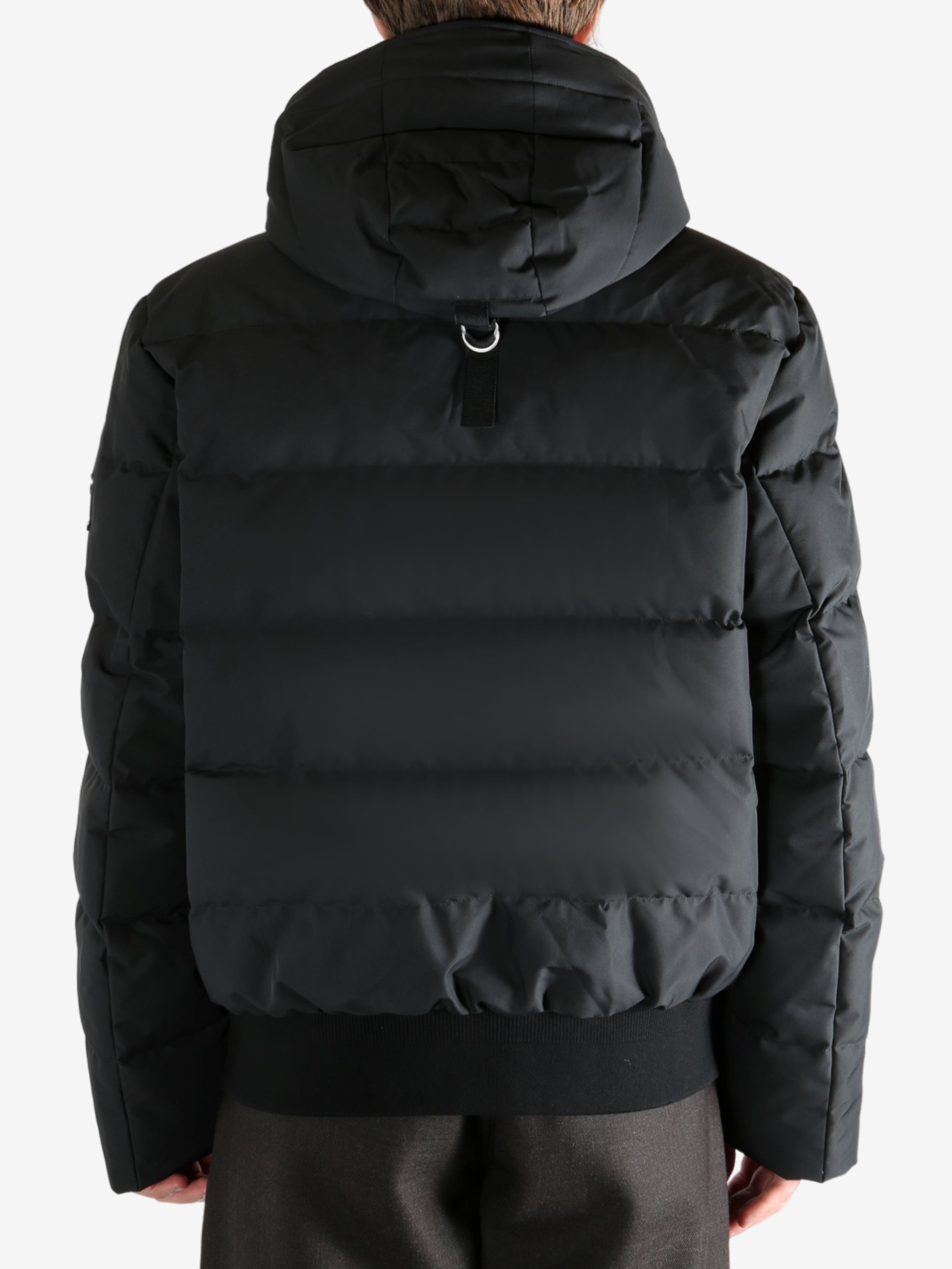 Black coat worn by a person, showing the coat's fit