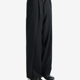 Black pants worn by a person, showing the pants' fit