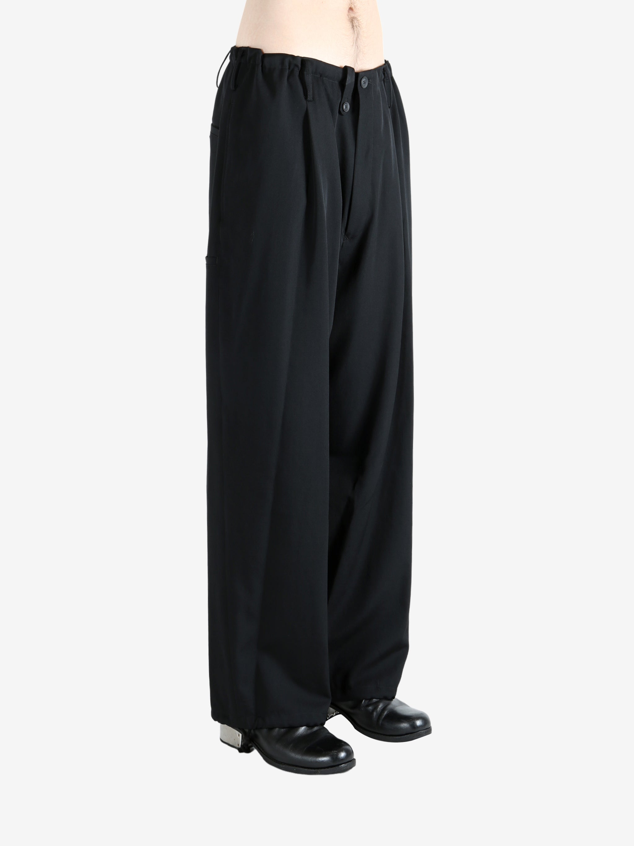 Black pants worn by a person, showing the pants' fit