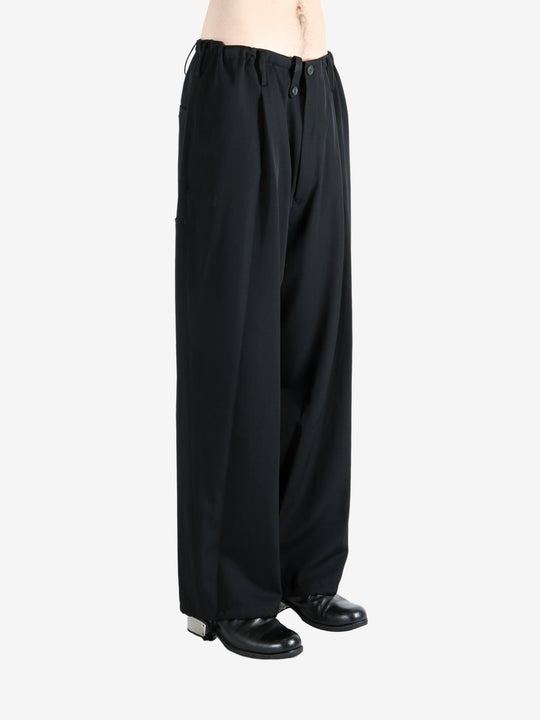 Black pants worn by a person, showing the pants' fit