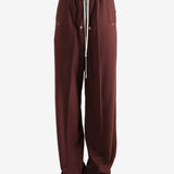 Burgundy pants worn by a person, showing the pants fit