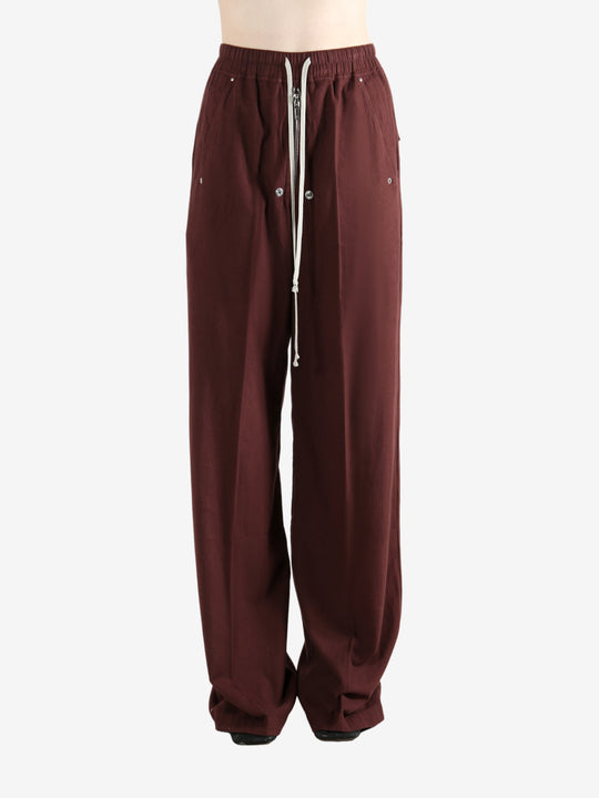 Burgundy pants worn by a person, showing the pants fit