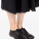 Black shoes worn by a person, showing the shoes' fit