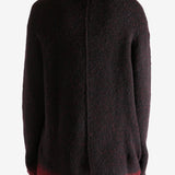 Black knitwear worn by a person, showing the knitwear's fit