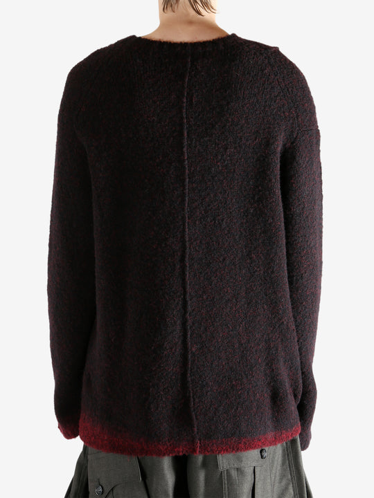 Black knitwear worn by a person, showing the knitwear's fit