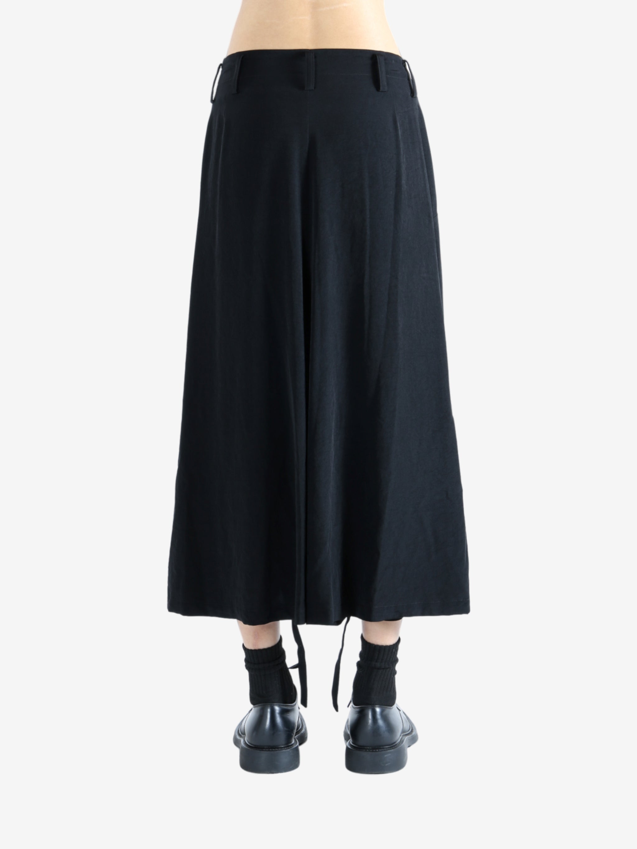 Black pants worn by a person, showing the pants' fit