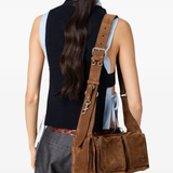 Brown leather bag worn by a person, showing the bag fit
