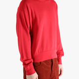 Red knitwear worn by a person, showing the knitwear's fit
