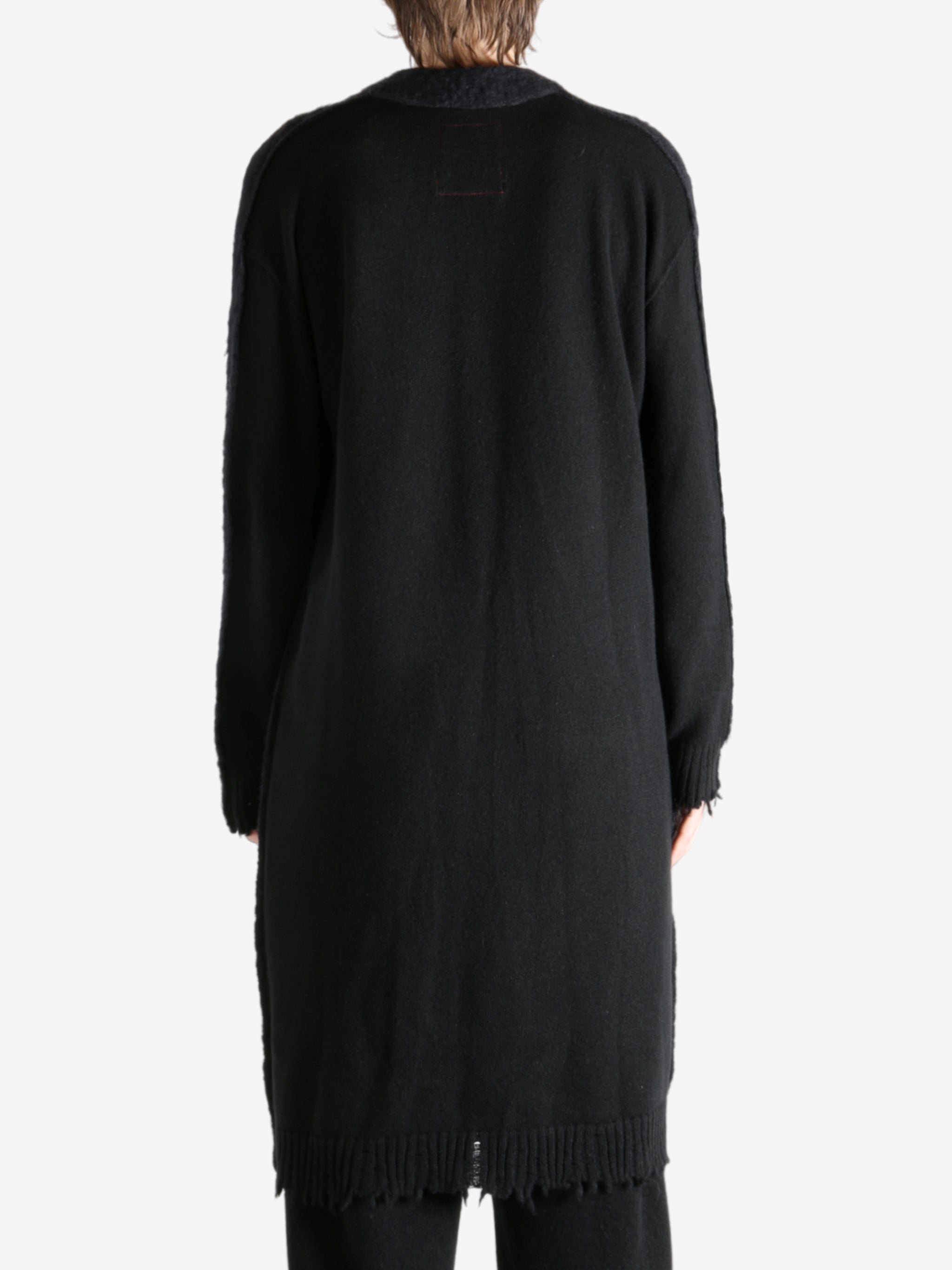 Black coat worn by a person, showing the coat's fit