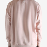Pink sweatshirt worn by a person, showing the sweatshirt's fit