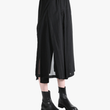 Black pants worn by a person, showing the pants fit