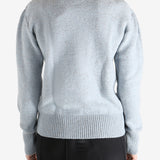 Blue sweater worn by a person, showing the sweater's fit