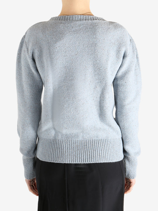 Blue sweater worn by a person, showing the sweater's fit