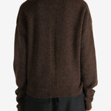Brown knitwear worn by a person, showing the knitwear's fit