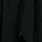 Close up of black skirt , showing texture of the polyester fabric