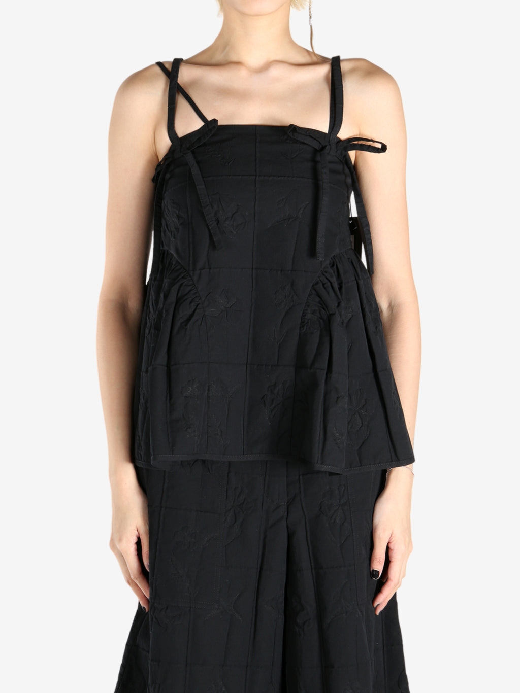Black top worn by a person, showing the top fit