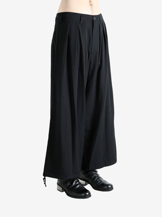 Black pants worn by a person, showing the pants fit