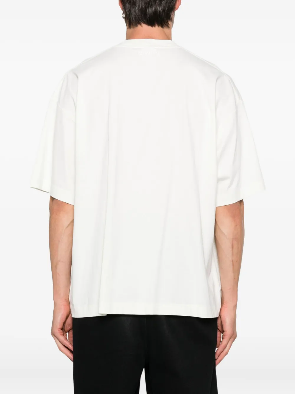 White t-shirt worn by a person, showing the shirt's fit