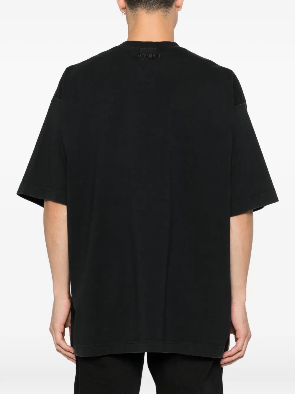 black t-shirt worn by a person, showing the t-shirt fit