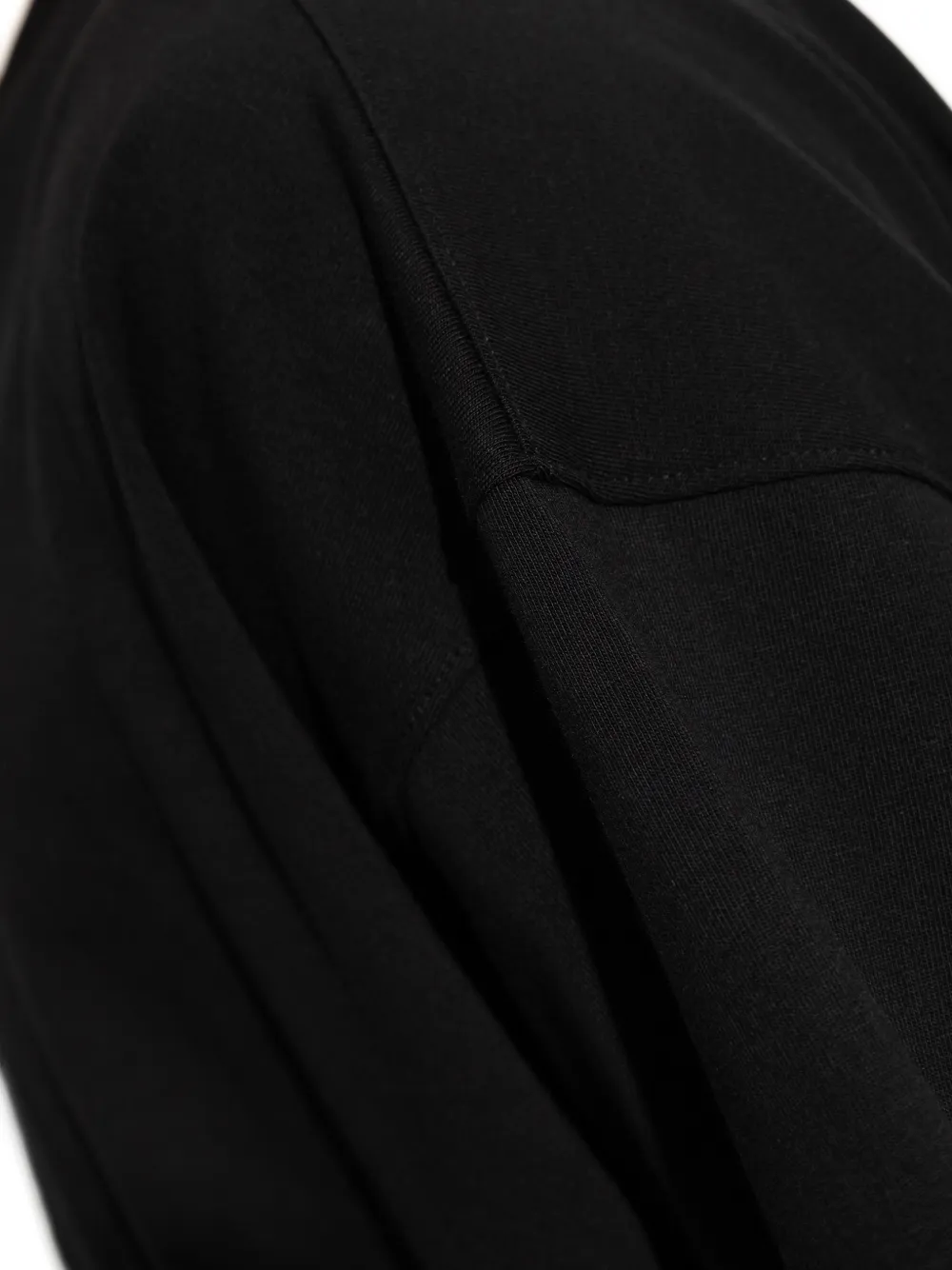 close up of black t-shirts, showing texture of the cotton fabric
