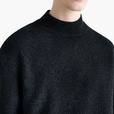 Close up of black knitwear, showing texture of the wool fabric