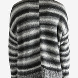 Black knitwear worn by a person, showing the knitwear's fit