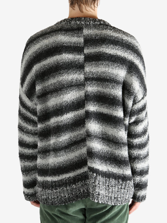 Black knitwear worn by a person, showing the knitwear's fit