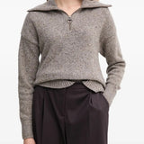 Grey knitwear worn by a person, showing the knitwear's fit