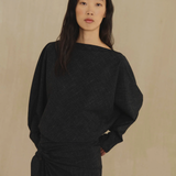 Black top worn by a person, showing the top fit