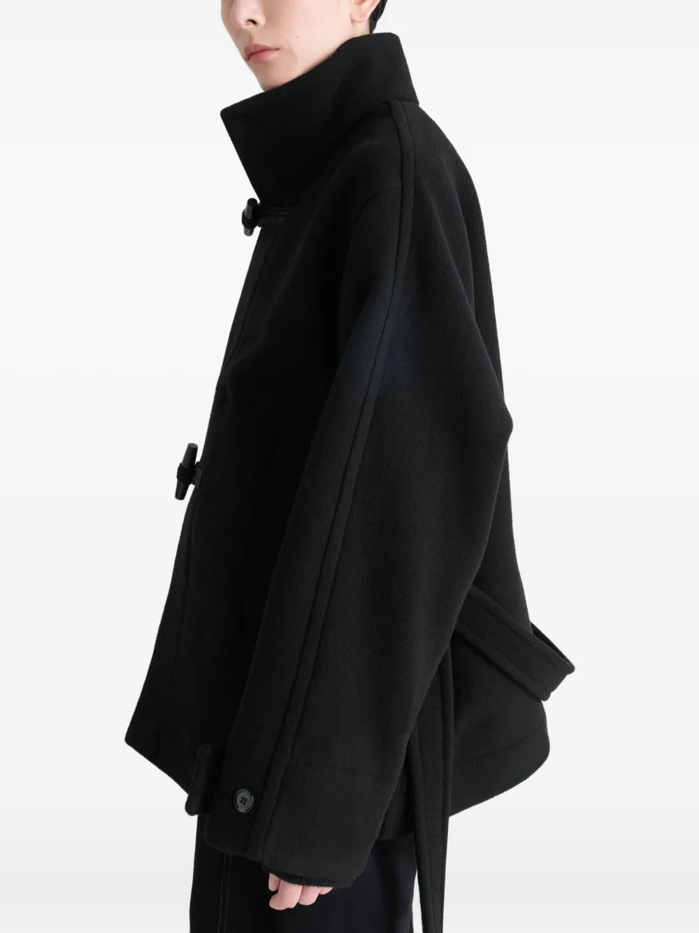 Black coat worn by a person, showing the coat's fit