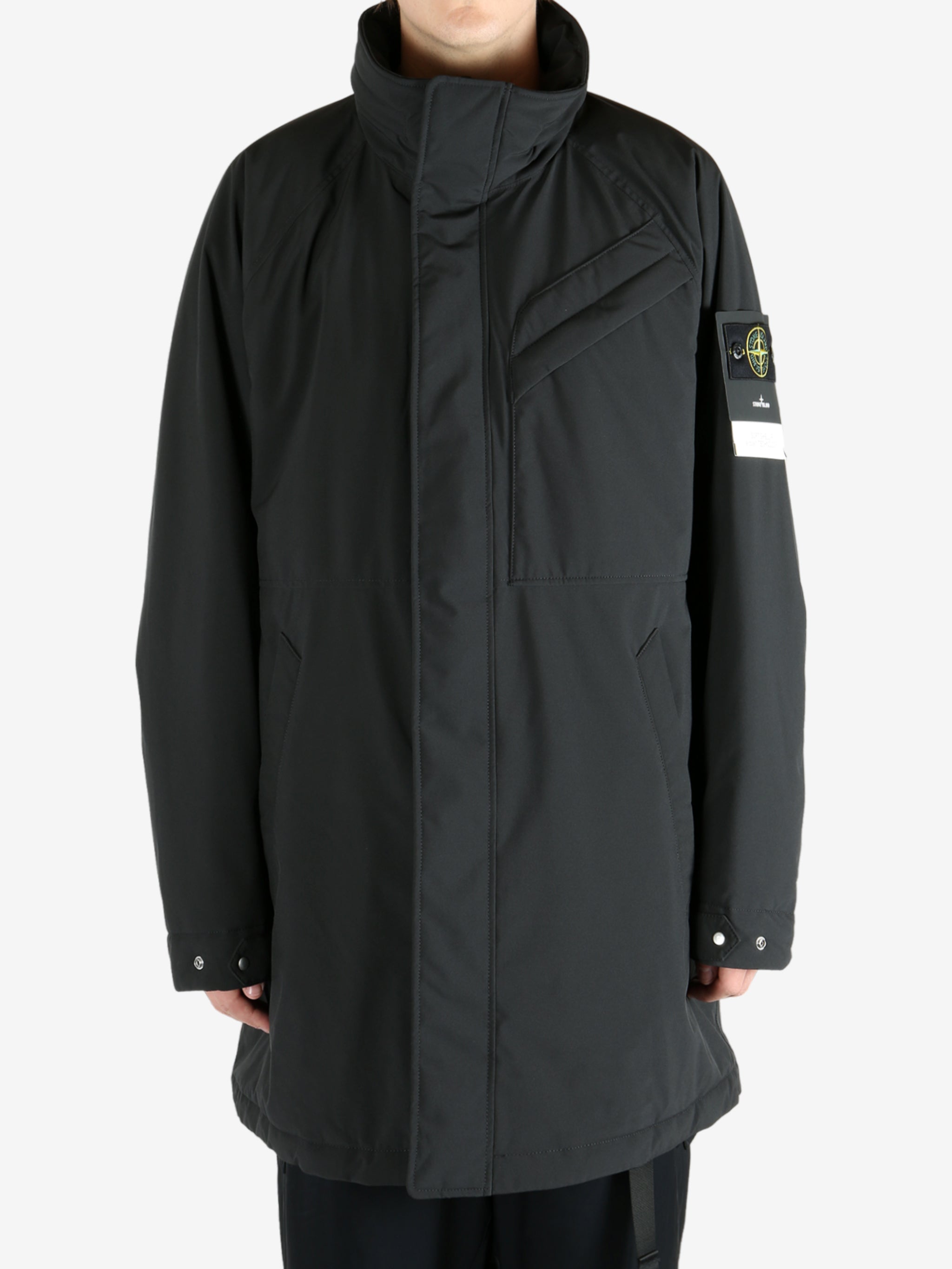 Black coat worn by a person, showing the coat fit