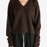 Brown knitwear worn by a person, showing the knitwear's fit