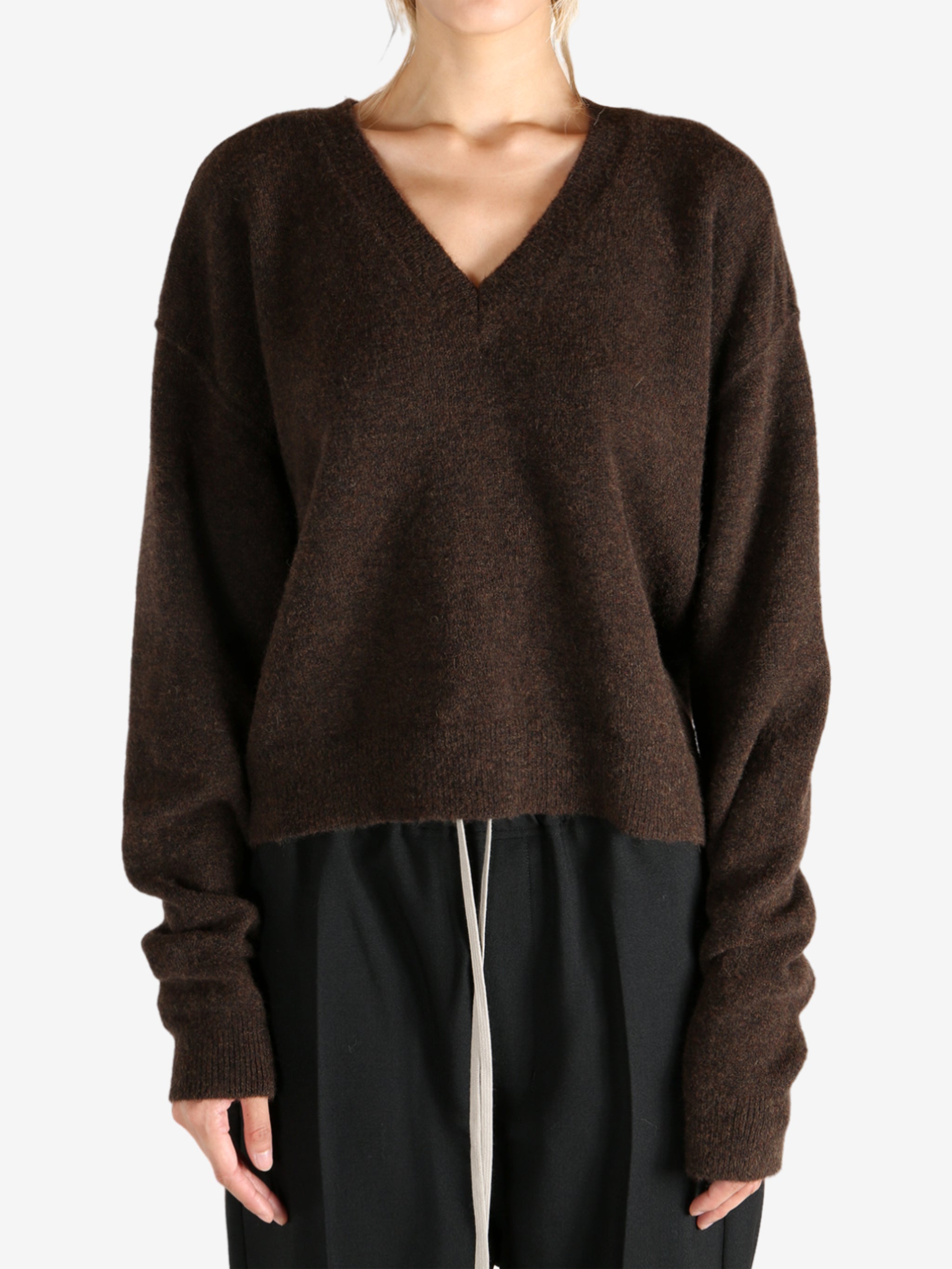 Brown knitwear worn by a person, showing the knitwear's fit