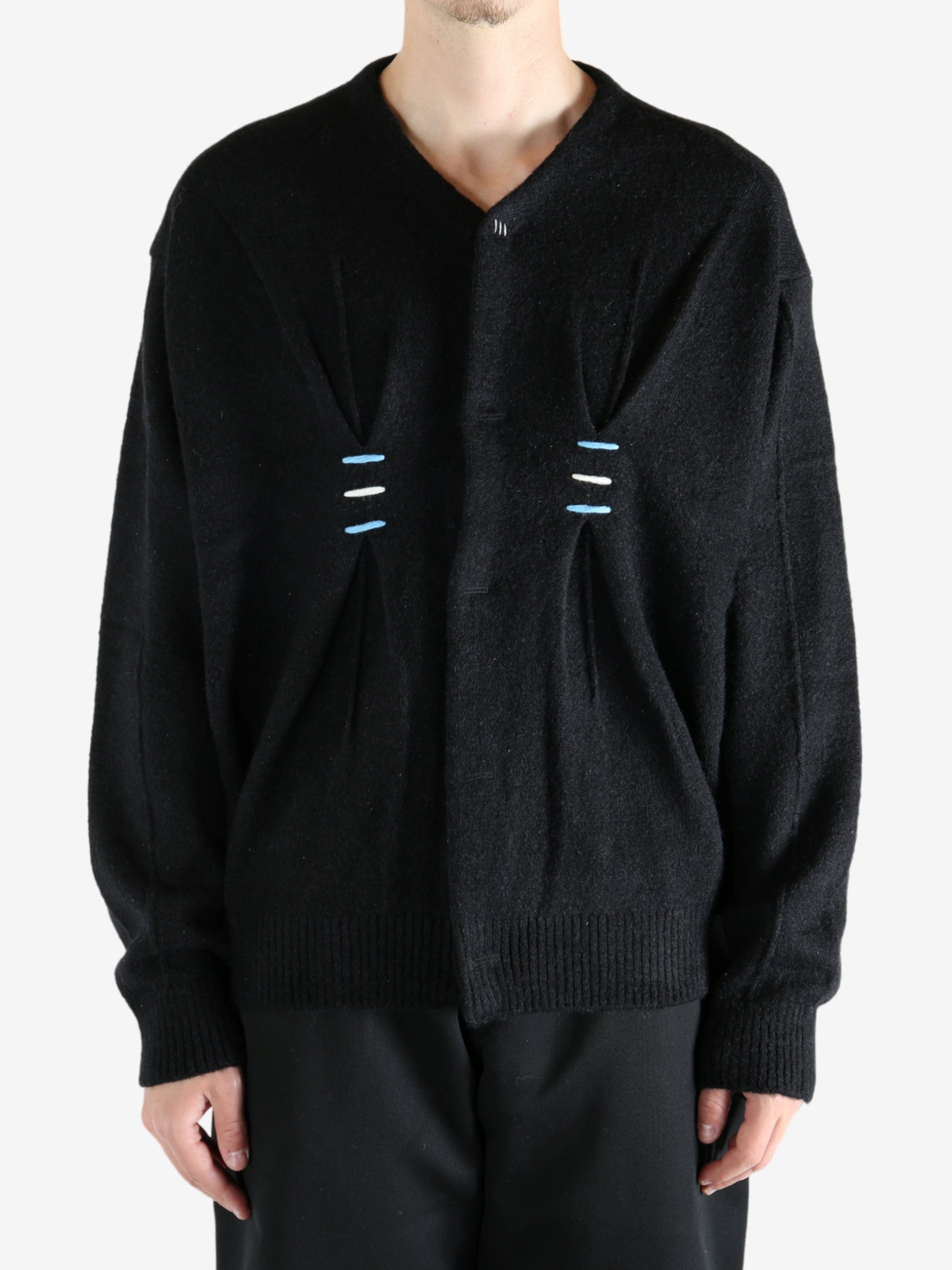 Black sweater worn by a person, showing the sweater's fit