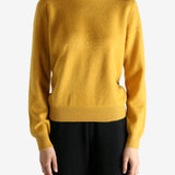 Yellow sweater worn by a person, showing the sweater's fit