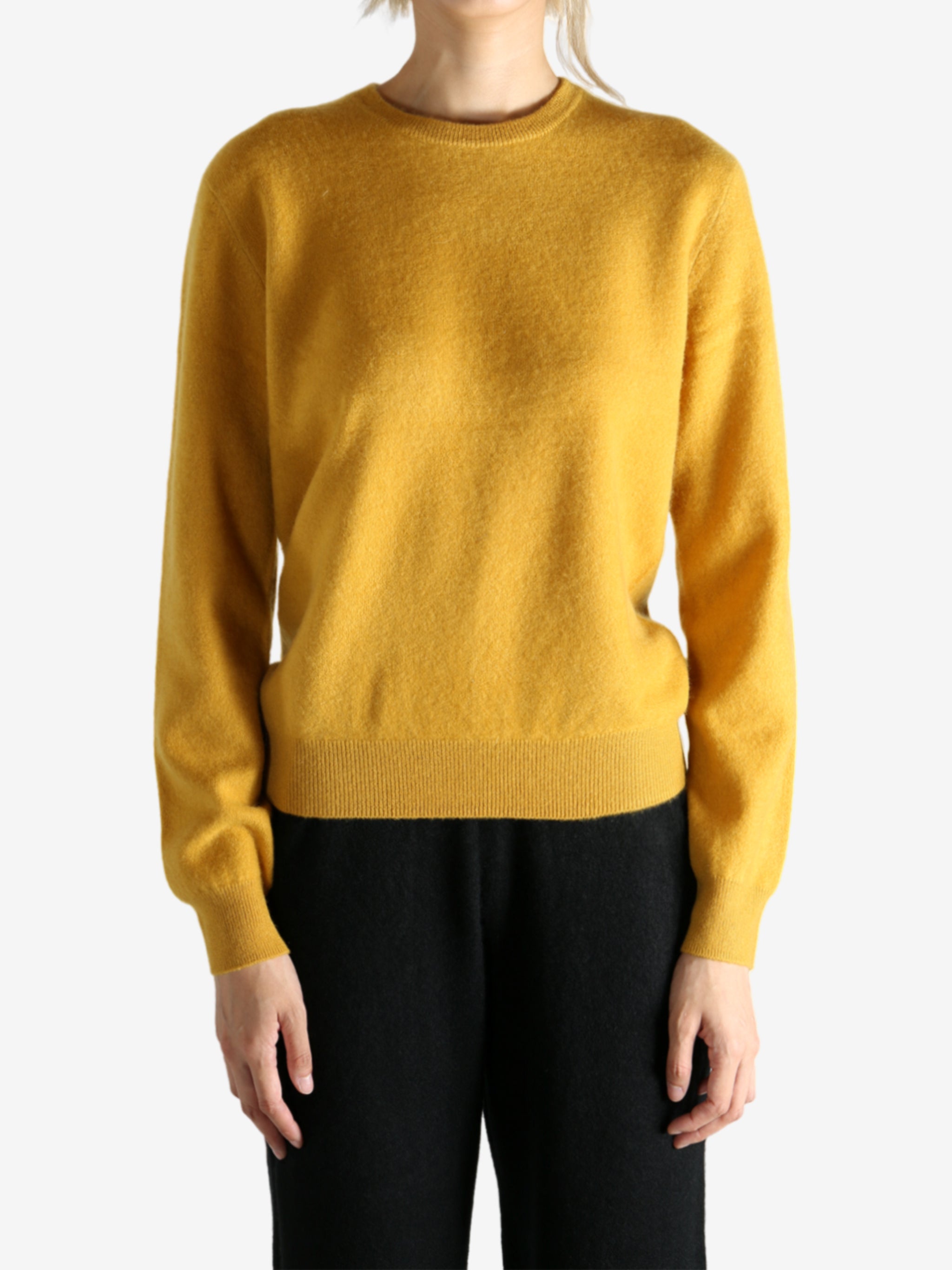 Yellow sweater worn by a person, showing the sweater's fit
