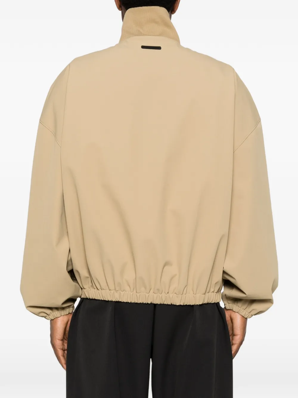 Tan coats worn by a person, showing the coats fit