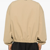 Tan coats worn by a person, showing the coats fit