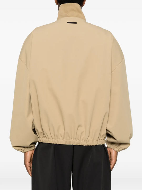 Tan coats worn by a person, showing the coats fit
