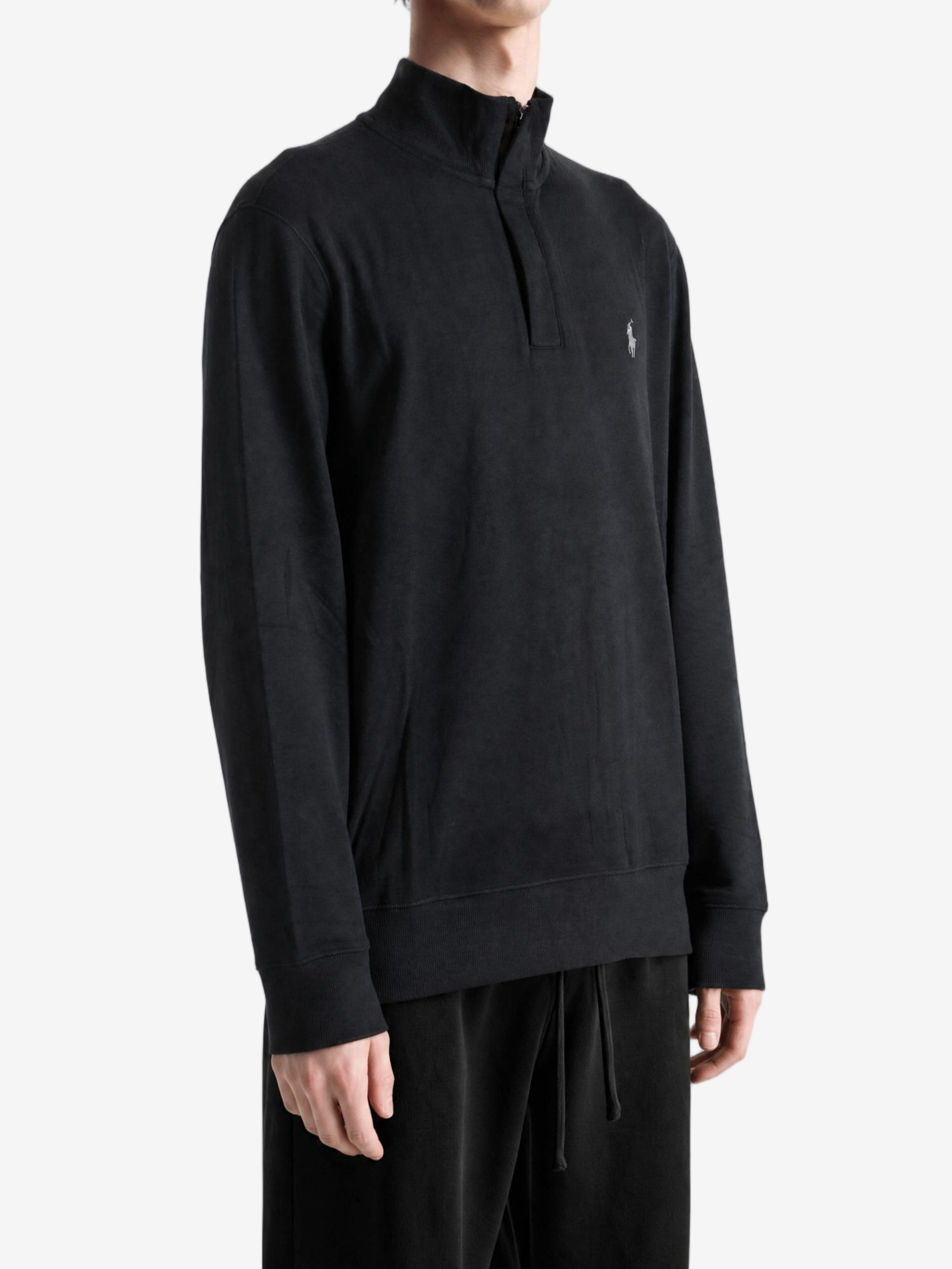 Black knitwear worn by a person, showing the knitwear fit