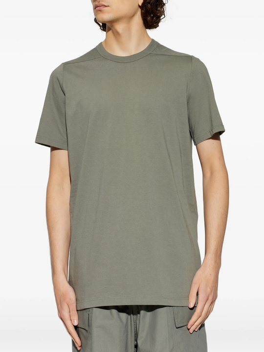 green t-shirts,worn by a person,showing the t-shirts fit