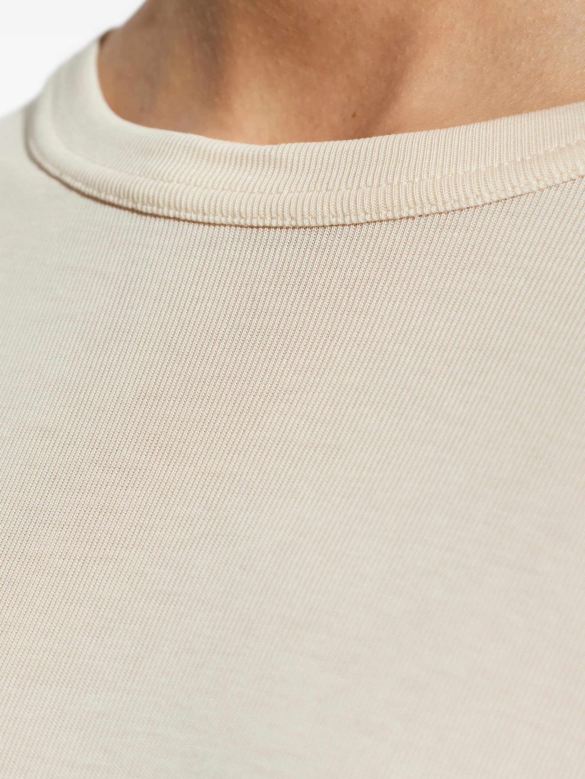 Close up of white t-shirts, showing texture of the cotton fabric