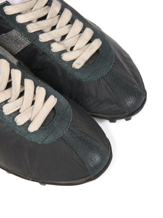 Close up of green sneakers, showing texture of the Polyester fabric
