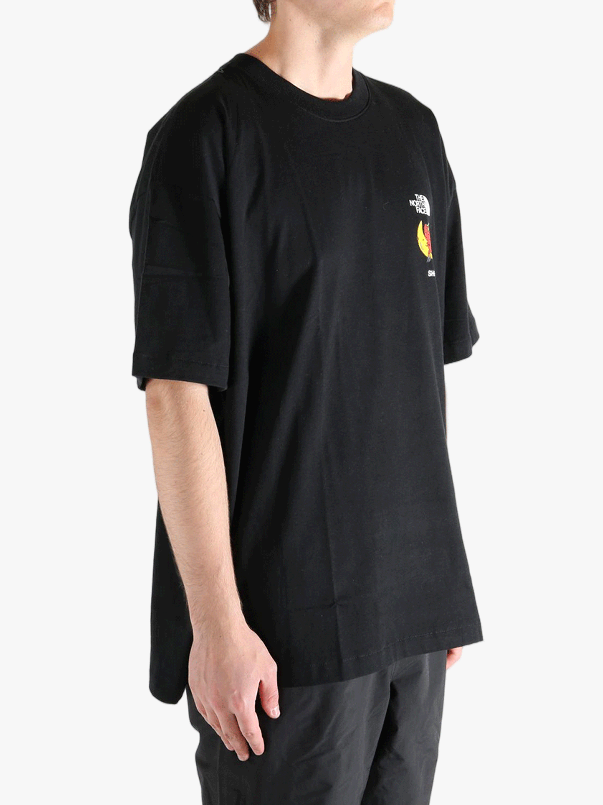 Black tee worn by a person, showing the tee fit