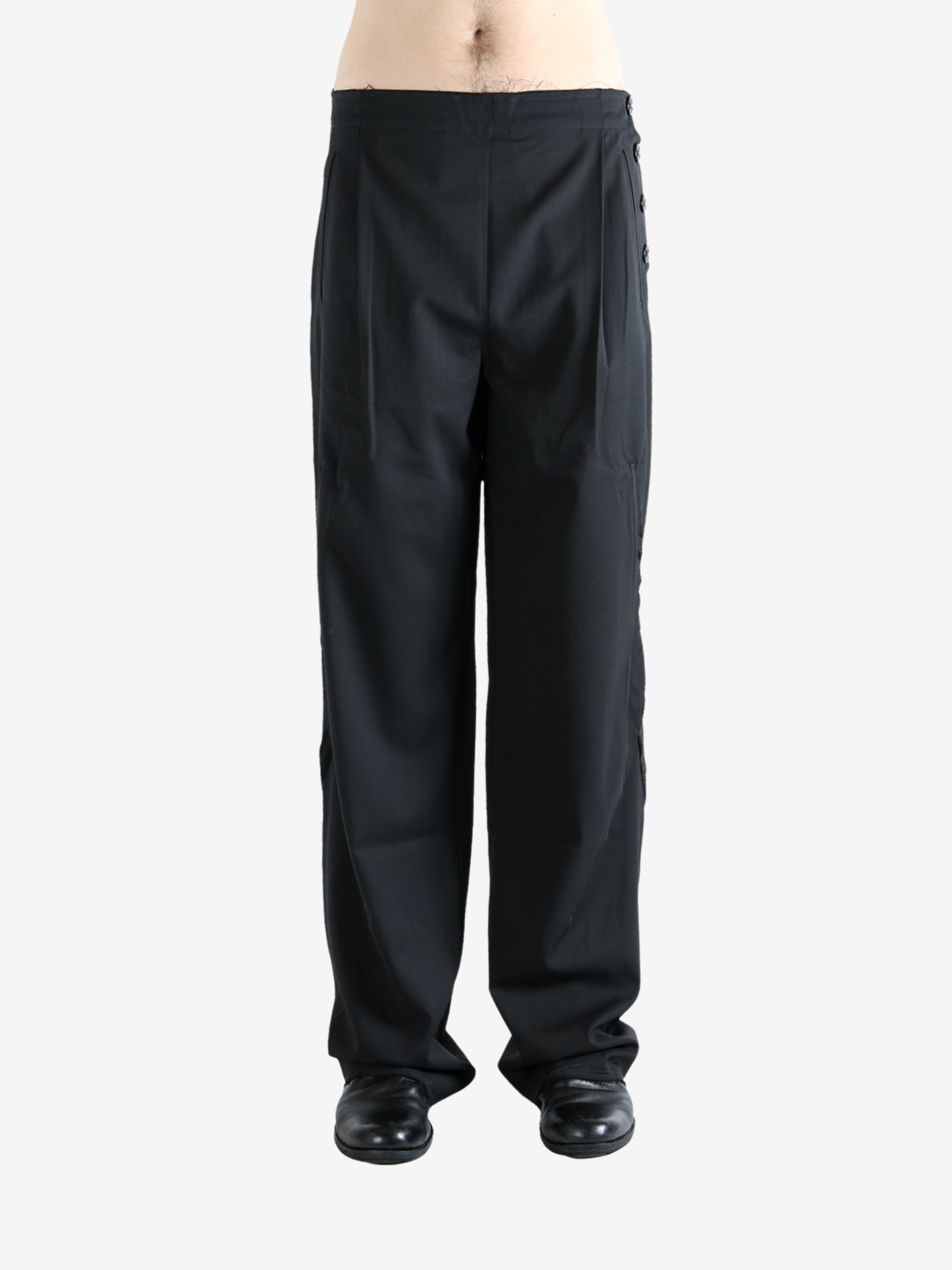 Black pants worn by a person, showing the pants' fit