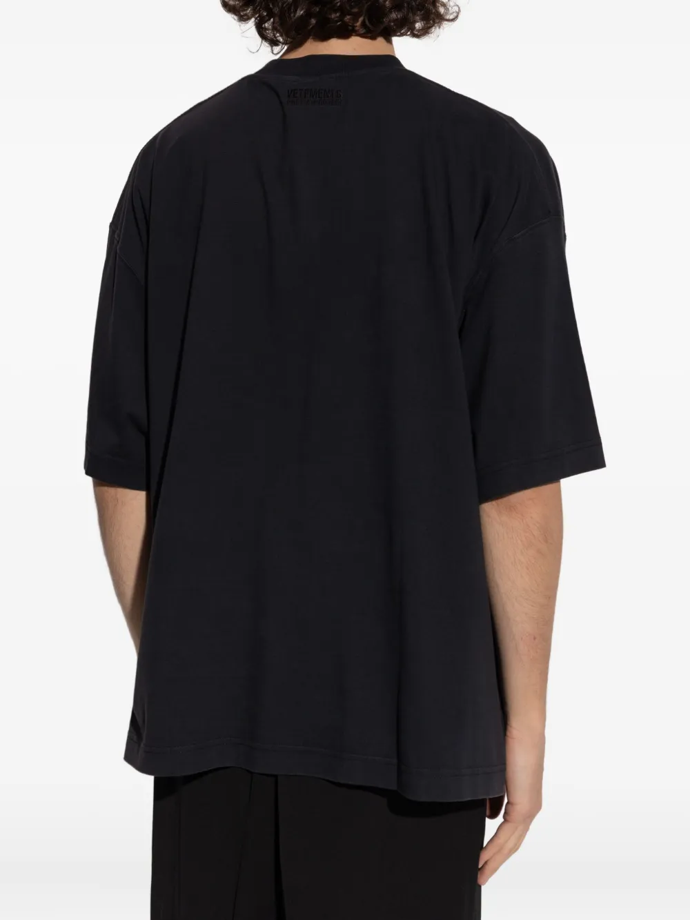 Black t-shirt worn by a person, showing the shirt's fit