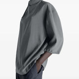 Grey top worn by a person, showing the top's fit